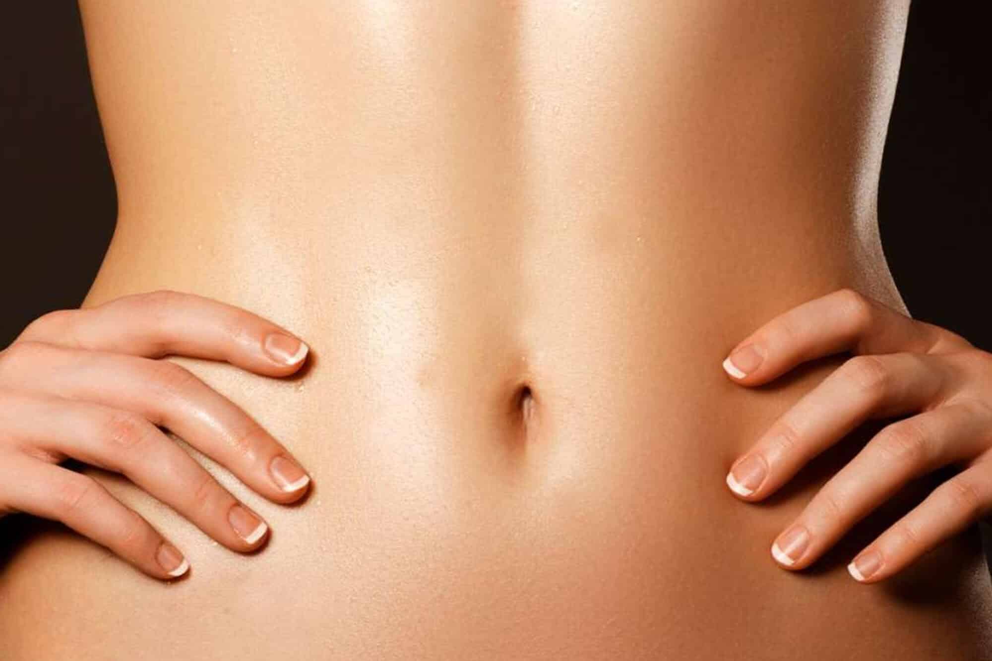 Patient showing toned and tightened abdomen after successful abdominoplasty surgery.