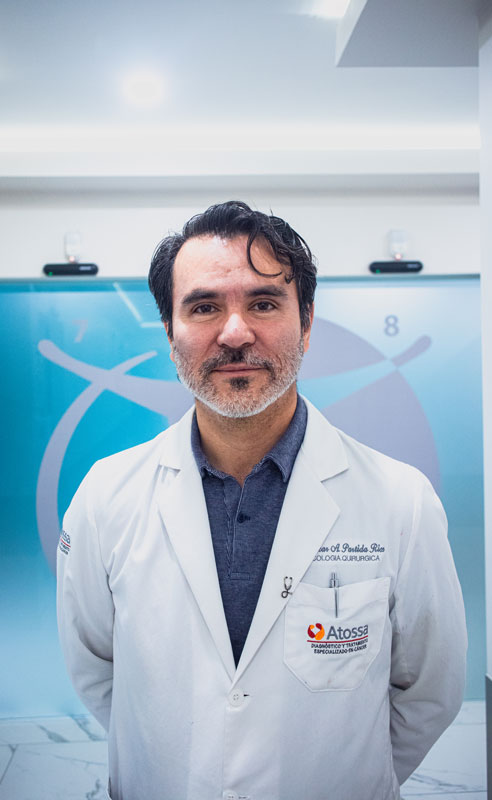 Doctor in a white lab coat standing and smiling in a medical office, with medical symbols on the frosted glass background.
