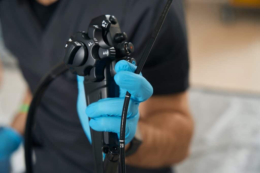 Expert diagnostician demonstrating endoscopic equipment before endoscopy
