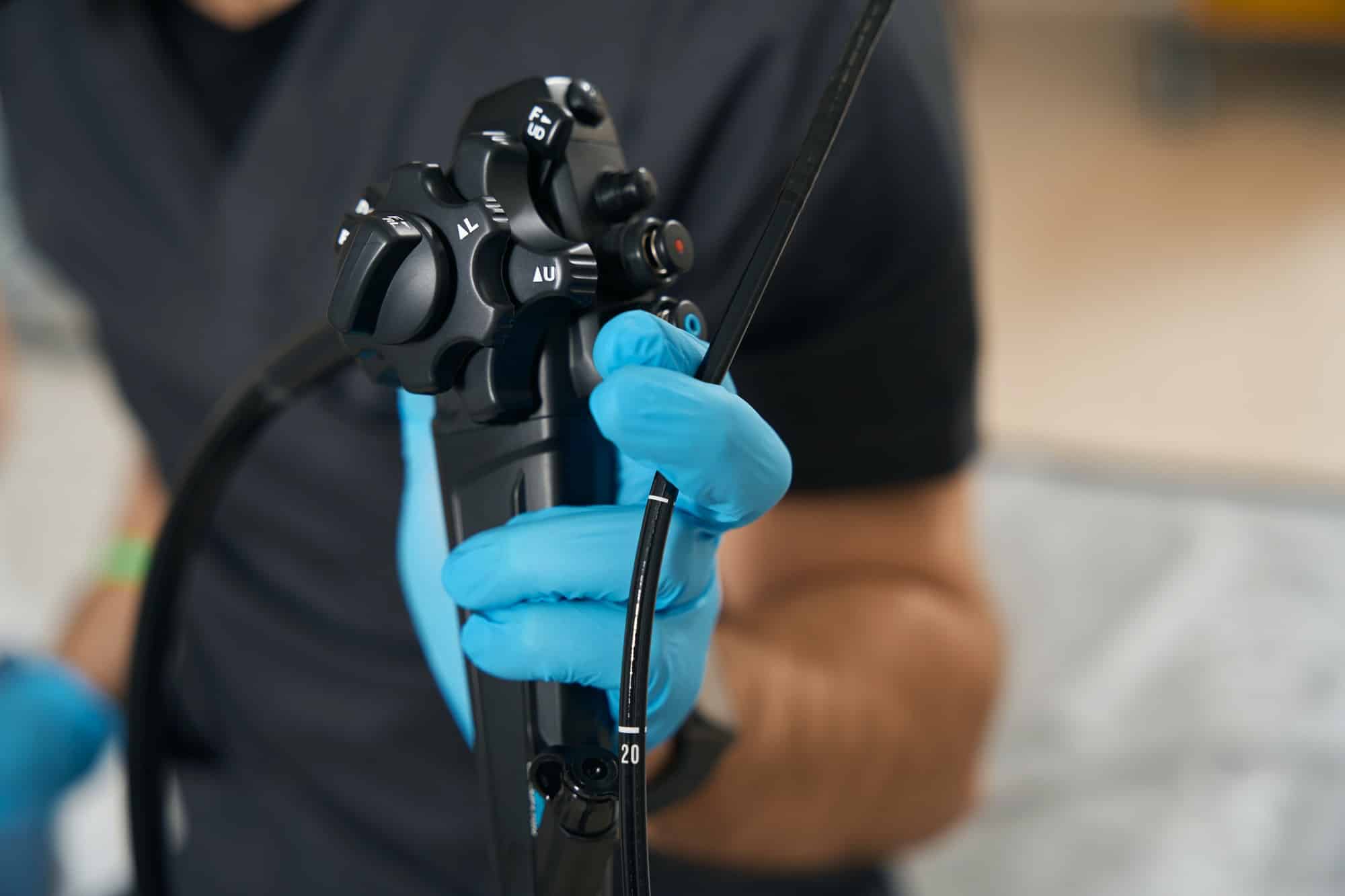 Expert diagnostician demonstrating endoscopic equipment before endoscopy