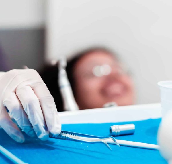 image of the hands of a professional dentist holding a dental cleaning instrument. image of the hands of a professional dentist holding a dental cleaning instrument.